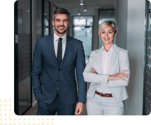 Business professionals standing in office hallway.