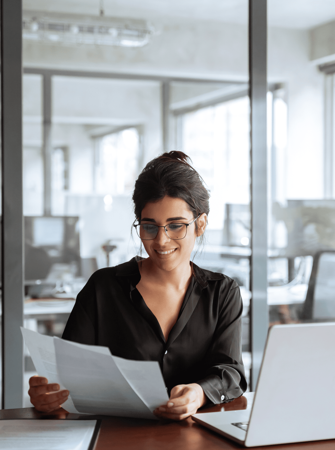 Woman reading documents in modern office.