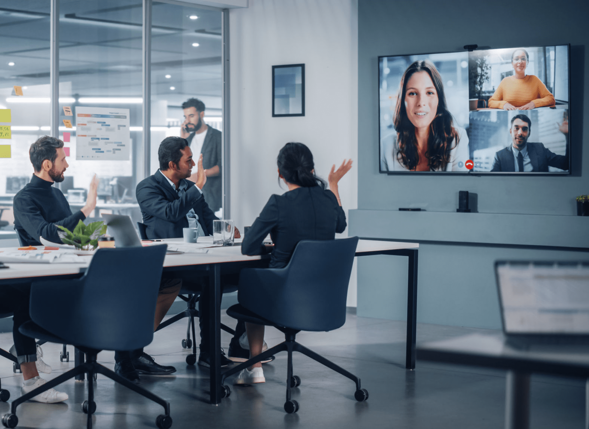 Office meeting with video conference participants.